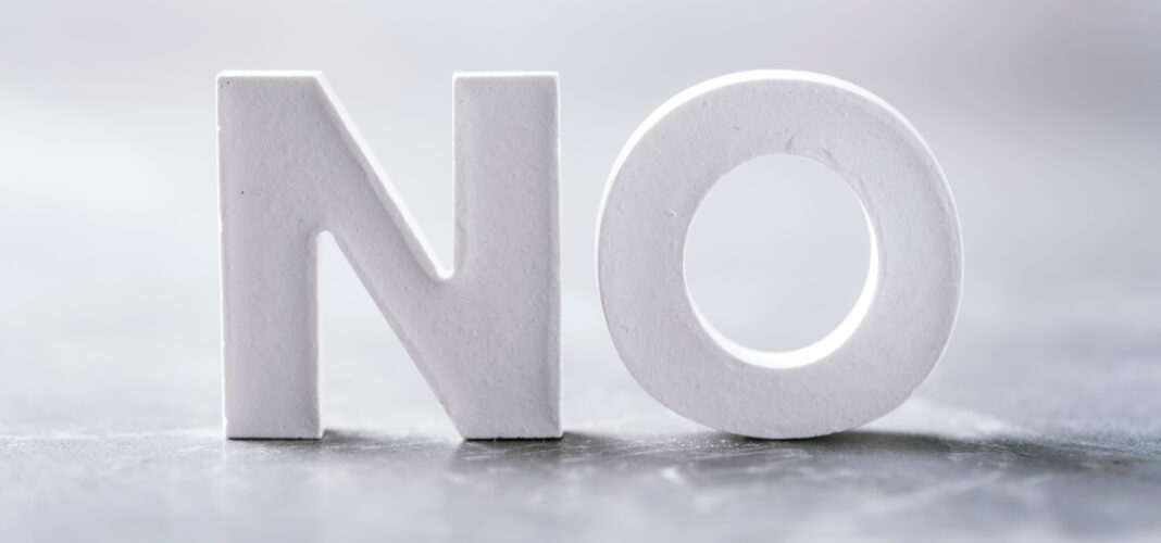 Word NO made with cement letters on grey marble background. Copy space. Business concept